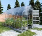 Greenhouse with transparent roof and walls on a grassy area with trees in the background