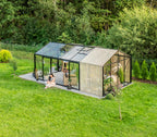 Modern glass cabin in a forest setting with a person sitting inside.