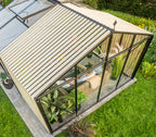 Garden room with glass walls and wooden roof, surrounded by greenery